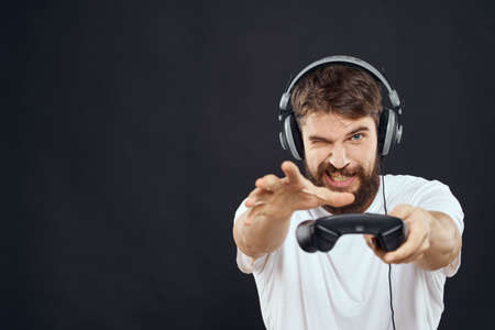 man in headphones with gamepad fun entertainment games lifestyle dark background