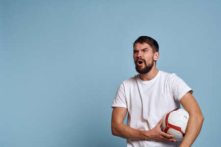 male coach with soccer ball on blue background