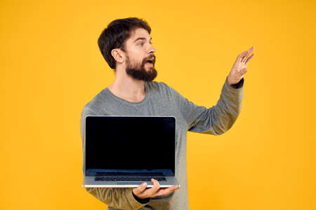 man with laptop on yellow isolated backgroundの写真素材