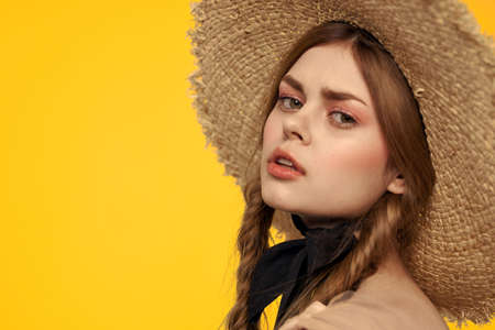 Portrait woman in straw hat on yellow background