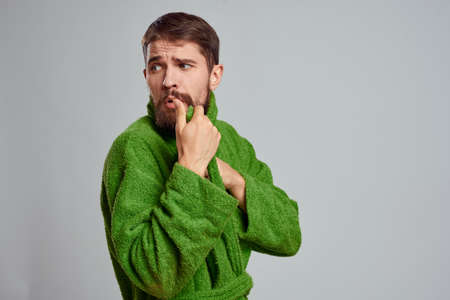 Bearded man in green robe on gray background close-upの写真素材