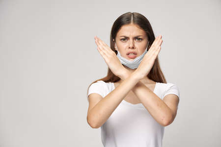 Woman wearing medical mask displeased expression crossed her arms in front of her safetyの写真素材