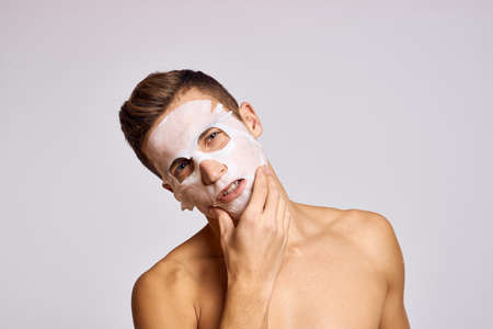 man with cleansing mask on face against black dots on isolated background cropped viewの写真素材