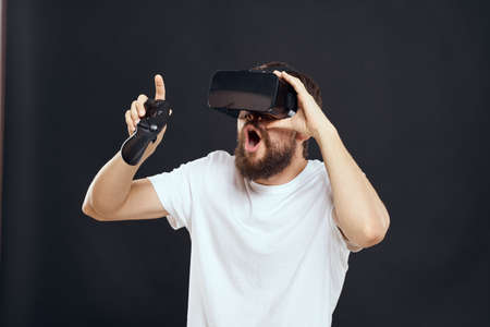 man wearing virtual reality glasses with gamepad in hand technology games leisure dark backgroundの写真素材