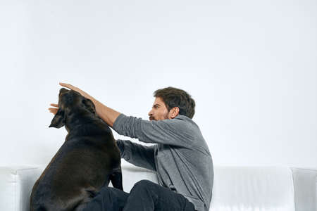 Man with a pet dog on the couch fun friends emotions light room
