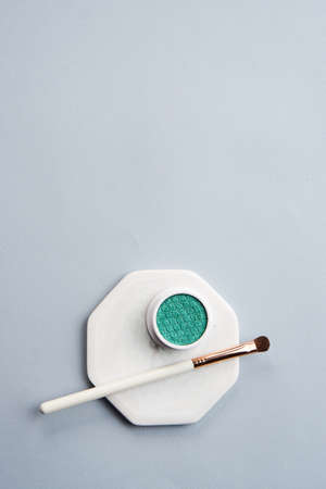 Green eyeshadow and makeup brush on white stand isolated backgroundの写真素材