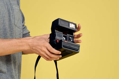 Photo camera in the hands of a man professional equipment hobby Creative approach studio cropped viewの写真素材