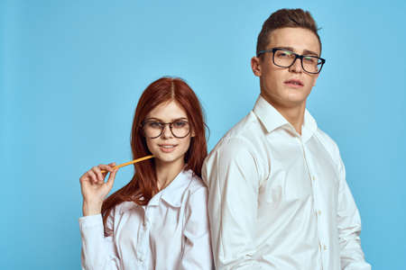 business woman and colleague man on a blue background in light clothes and documents in hands work