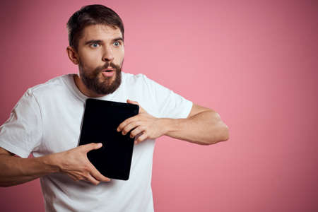 Man advertises a tablet on a pink background codes Space cropped view of emotions white t-shirt...