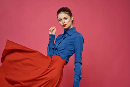 Woman in blue shirt and red cubes on pink background fun emotions model cropped viewの写真素材