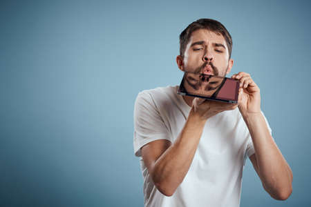 A guy with a tablet on a blue background and in a white T-shirt sensor Monitor Modelの写真素材