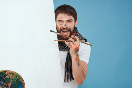 Male artist palette brush easel art hobby blue backgroundの写真素材