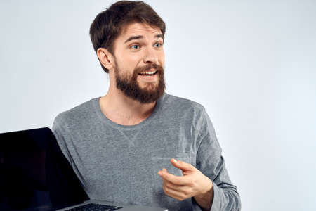 A man in a gray sweater with a laptop hands lifestyle technology communication internet work