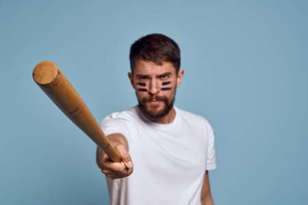 emotional man with a bat in his hand on a blue background and makeup on his face black lines energy t-shirt baseballの写真素材