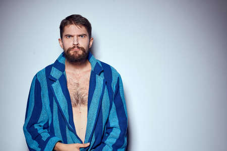 emotional man in a blue striped robe with a belt on a light background cropped view close-upの写真素材