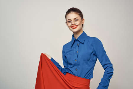 woman model in blue shirt and red skirt glasses beautiful face makeup studioの写真素材