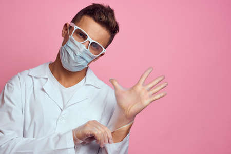 doctor in medical gloves with face mask on pink background cropped viewの写真素材