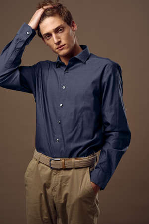 A business man in a blue shirt straightens his hairの写真素材