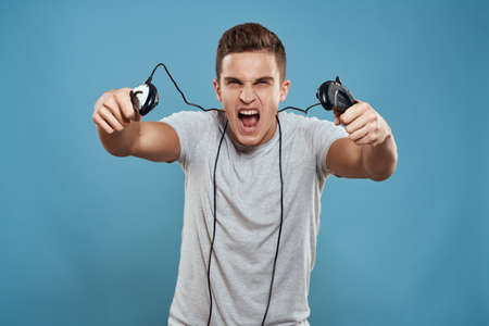 Man with joysticks wires technology games entertainment leisure fun blue background
