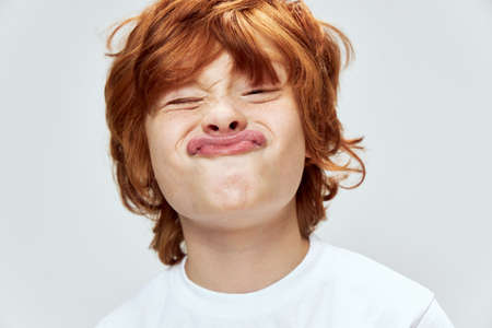 grimacing redhead boy face close up fun childhoodの写真素材