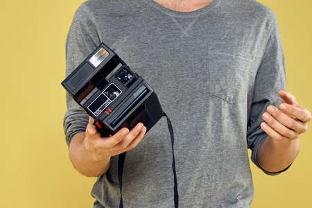 Photo camera in the hands of a man professional equipment hobby Creative approach studio cropped viewの写真素材