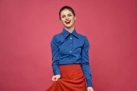 Woman in blue shirt and red cubes on pink background fun emotions model cropped viewの写真素材