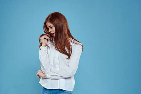 Elegant woman white shirt jeans studio lifestyle blue backgroundの写真素材