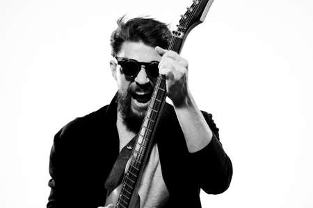 man with guitar in hands musician rock star performance lifestyle light background