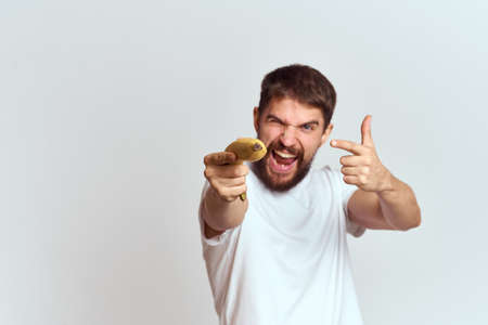 Cheerful man with a banana in his hands on a light background fun emotions Cropped view Copy Spaceの写真素材