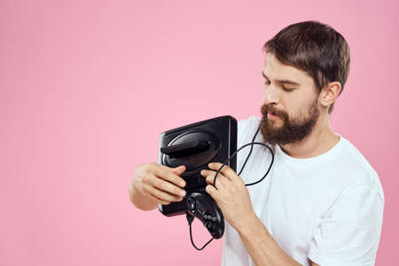 Man with prefix in hand joystick games lifestyle fun pink background white t-shirt