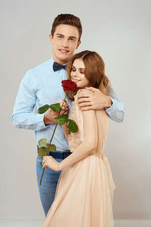 Young couple hugs romance dating lifestyle relationship light background red roseの写真素材