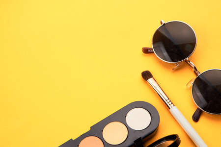 Eyeshadows on a yellow background professional cosmetics makeup brushes soft sponge fashion glassesの写真素材