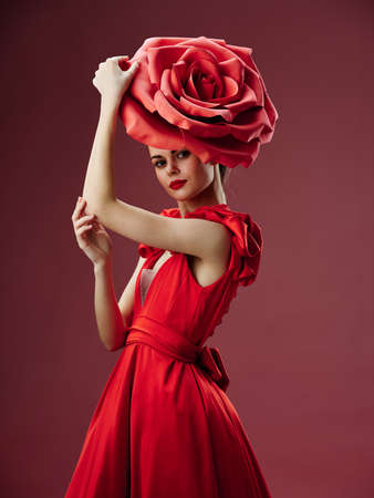 model with a decorative flower on her head and in a red dressの写真素材
