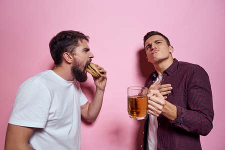 Two men drink beer friendship drunk alcohol lifestyle pink background