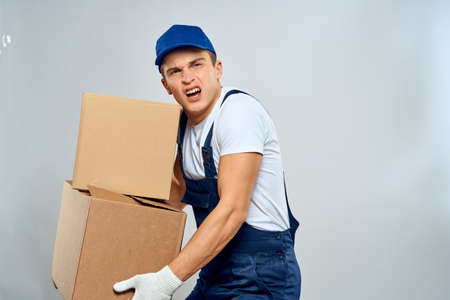 working man in uniform with boxes in his hands delivery loader lifestyleの写真素材