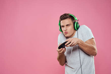 A man with a joystick in his hands headphones playing games entertainment lifestyle white t-shirt...