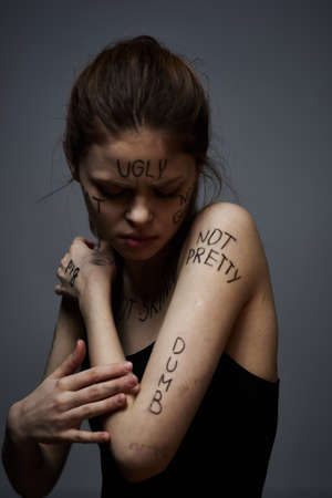 Woman with inscriptions on body frustration stress emotions lifestyle gray background