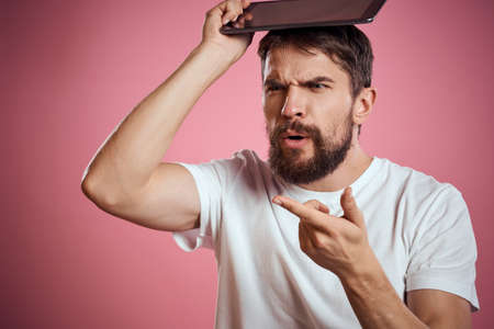 Man advertises a tablet on a pink background codes Space cropped view of emotions white t-shirt model new technologiesの写真素材