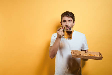 Bearded man with mug of beer fast food diet food fun alcohol lifestyle yellow background