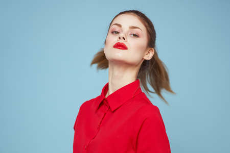 attractive woman in bright clothes on blue background gesturing with hands and red lips makeup...