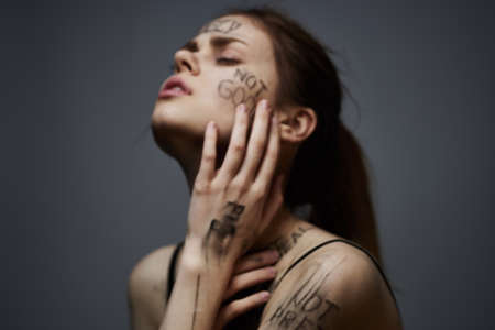 woman with offensive inscriptions on her body touching herself with hands stress frustration hate