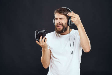 man in headphones with gamepad fun entertainment games lifestyle dark backgroundの写真素材