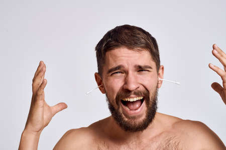 Bearded man with bare shoulders cotton swabs hygiene body care