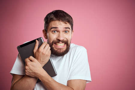 Man advertises a tablet on a pink background codes Space cropped view of emotions white t-shirt model new technologiesの写真素材
