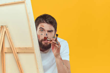 Male artist stands in front of easel emotions drawing Creative approach yellowの写真素材