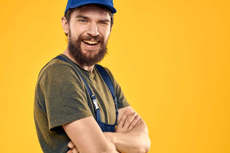 Worker man in uniform worker service yellow background emotion