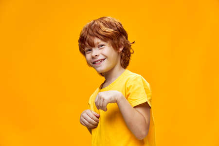 A child with red hair smiles and holds the palmの写真素材