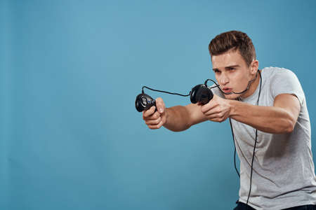 Man with joysticks wires technology games entertainment leisure fun blue backgroundの写真素材