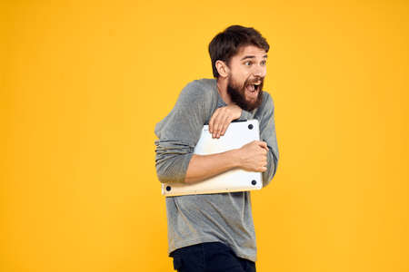 man with laptop wireless technology internet lifestyle work yellow isolated background