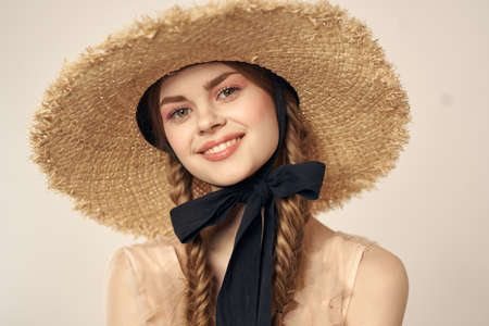 portrait of a romantic girl in a dress and a straw hat with a black ribbon emotions cropped viewの写真素材